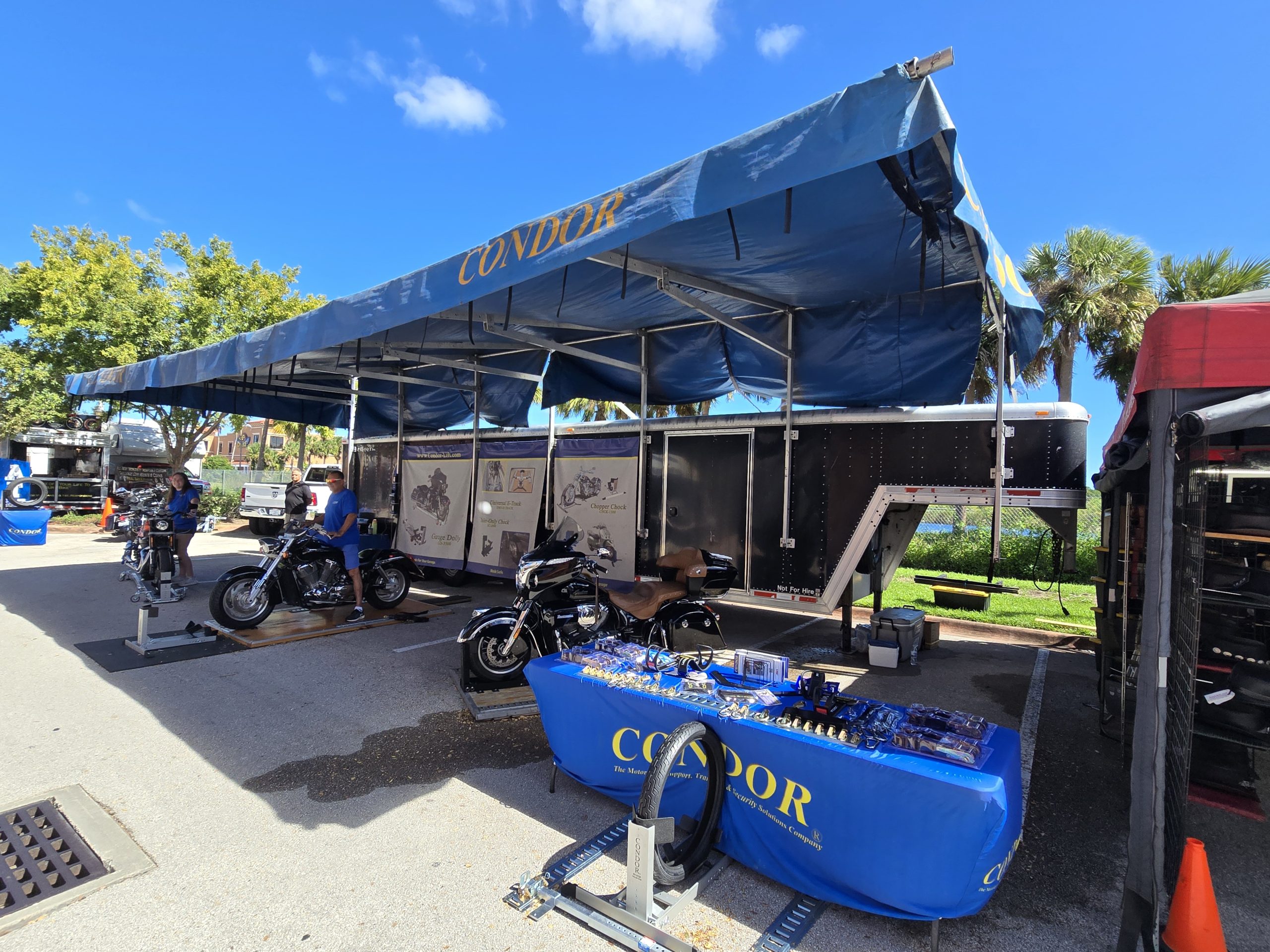 Condor motorcycle display under blue canopy at event.